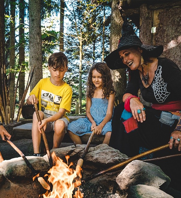 Woman with children around campfire