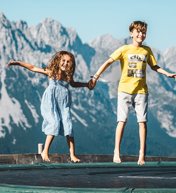 Mädchen und Junge beim Trampolin hüpfen