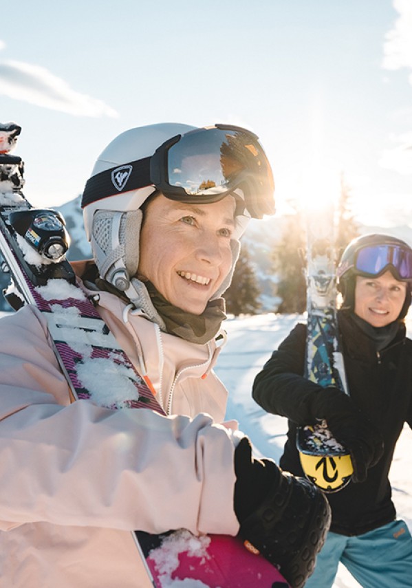 Zwei Frauen mit Skiern in der Hand